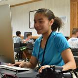 A media specialist works at a computer desk